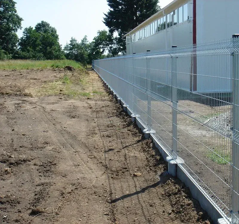 Horganyzott 3D táblás kerítés előregyártott beton lábazati elemmel ipari csarnok mellett